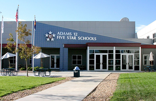 Landscape image of Adams 12 Five Star Schools with a well-manicured lawn and a sidewalk leading up to the front door